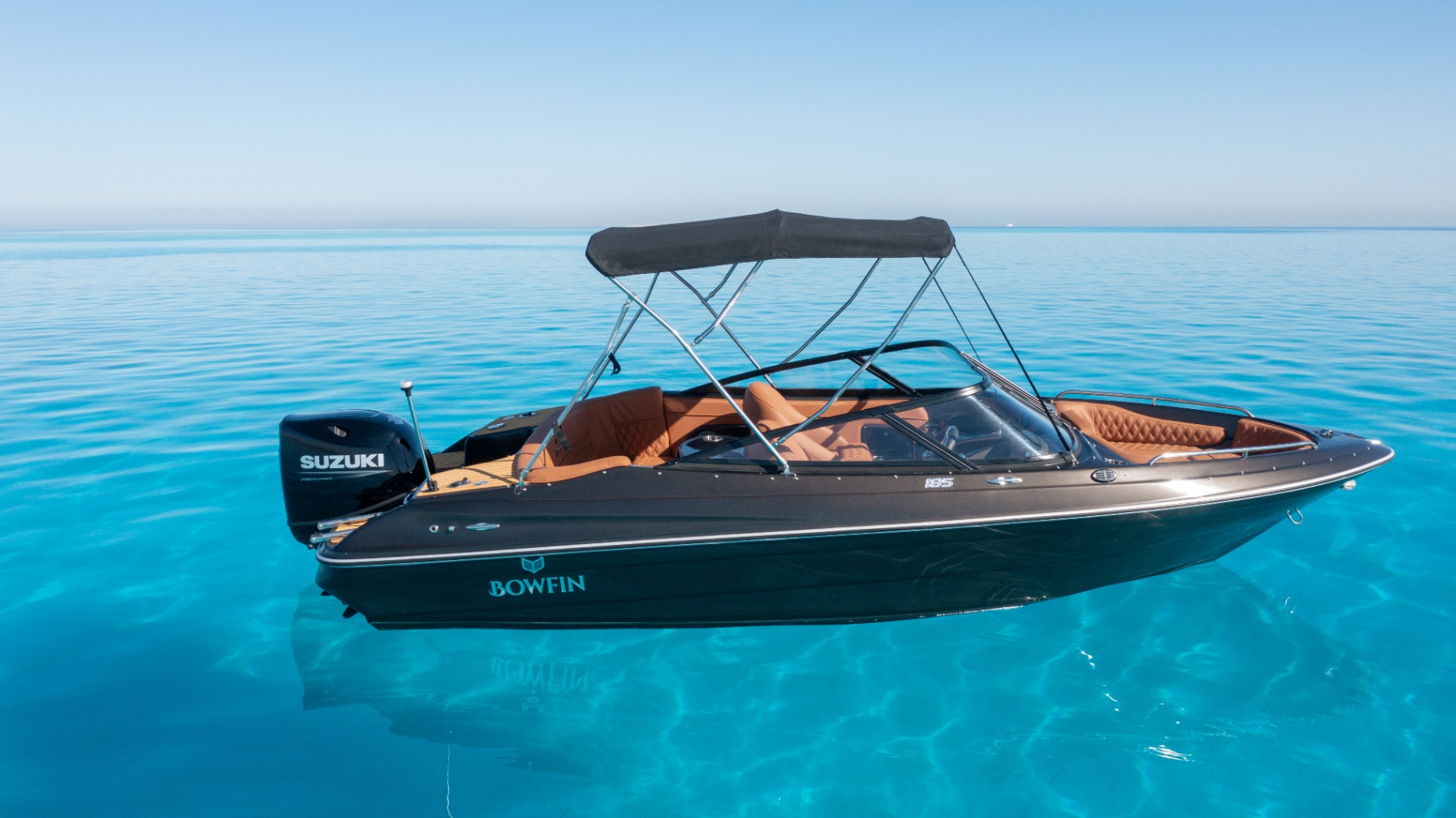Bowfin 185 floating on glass-calm turquoise water